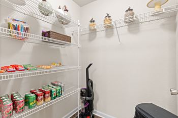 A walk in pantry with two shelves and two racks of food and drinks